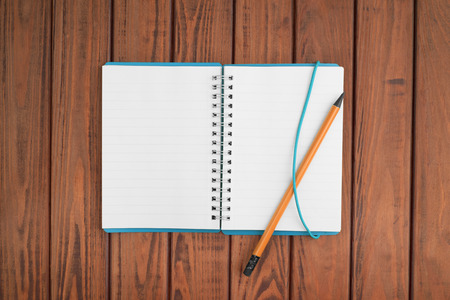 blank notebook with pen and pencil on wooden table, business conceptの写真素材