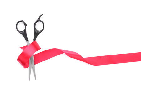 Scissors cut the red ribbon, isolated on white backgroundの写真素材