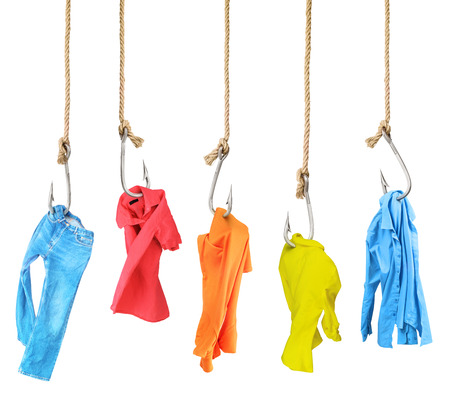 Concept of subjection. Clothes hanging on fishing hooks isolated on white background. Illustration of the dependence on the goods. Marketing trick.の写真素材