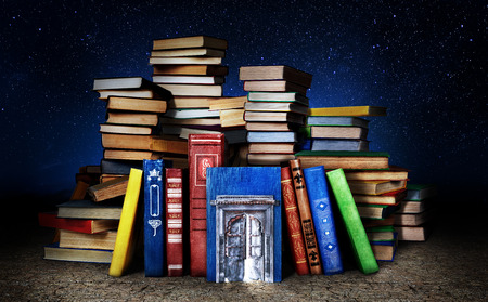 Concept of knowledge that is not used. Stack of books with door on a gloomy background. Concept of education.の写真素材