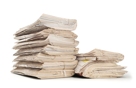 A stack of old newspapers isolated on white backgroundの写真素材