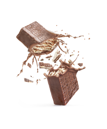 Waffles broken in half, with a chocolate splash isolated against a white backgroundの写真素材