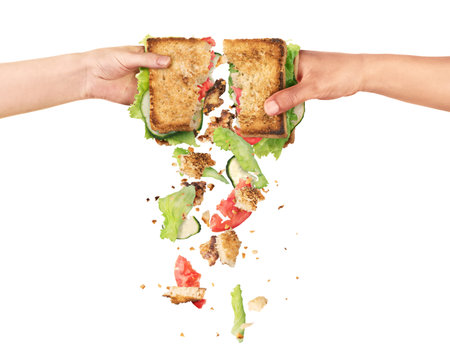 Hands of people of different nationalities tearing a sandwich from which the ingredients fall out...