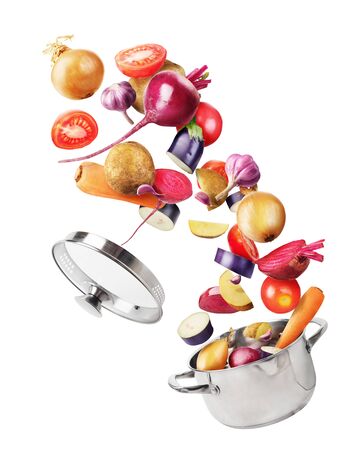 Cooking concept. Vegetables are falling on a pan isolated on white background. Healthy food.の写真素材