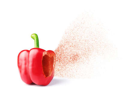 Paprika flavoring flies out of a hole in red pepperの写真素材
