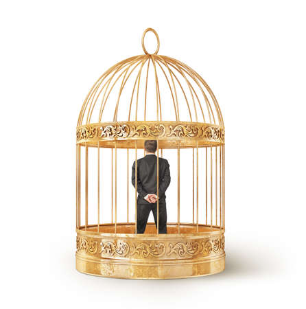 Man in business suit imprisoned in a golden cage isolated on white backgroundの写真素材