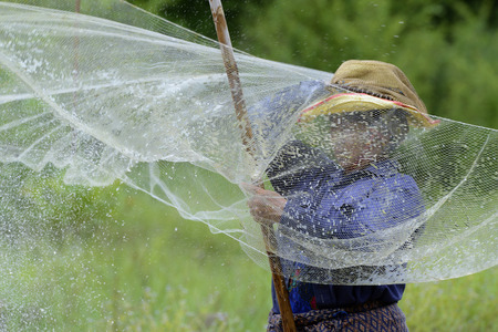 A woman while fishing in a river in the province of Amnat Charoen north-west of Ubon Ratchathani in the northeast of Thailand in South East Asiaのeditorial素材