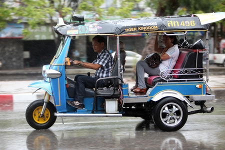 A tuk tuk on a street in rainy weather in Chiang Mai in Chiang Mai province in northern Thailand in Southeast Asiaのeditorial素材