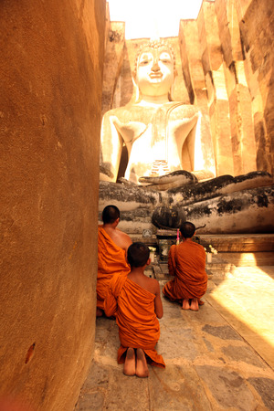 Monks admire the Buddha at Wat Si Chum temple in the temple complex of Old Sukhothai Province Sukhothai in the north of Thailand in South East Asiaのeditorial素材