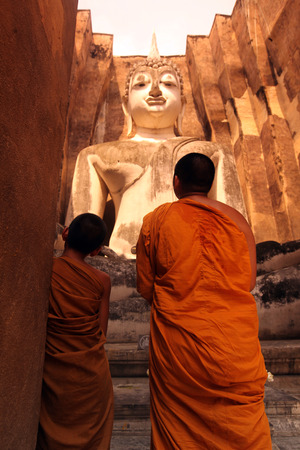 Monks admire the Buddha at Wat Si Chum temple in the temple complex of Old Sukhothai Province Sukhothai in the north of Thailand in South East Asiaのeditorial素材