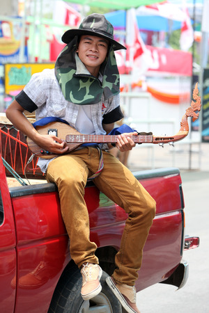 A musician of a traditional dance group shows at the festival parade at the Bun Bang Fai Rocket Festival in Yasothon or in Isan in the northeast of Thailandのeditorial素材