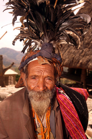 A farmer in Ceremonial clothing in front of his house in a farming village in the mountain village...