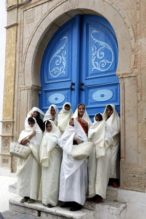 Women in traditional white veil in the old town of Sidi Bou Said in the twilight on the Mediterranean and North of the Tunisian capital, Tunisのeditorial素材