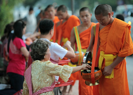 Monks in the early morning when collecting rice in the old town of Luang Prabang in Laos of Central Laos in South East Asiaのeditorial素材