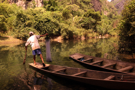 A fisherman in the village of Tha Tham Pa Fa Falang from near the town of Tha Khaek in central Laos on the border with Thailand in Southeast Asia in the countryside at the Nam Don or Don Riverのeditorial素材