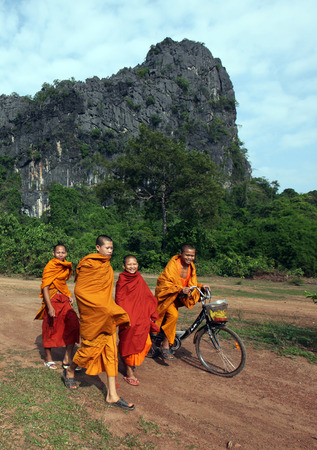 Monks in the hilly landscape along the highway 12 between the town and the village of Tha Khaek Mahaxai of May in central Laos on the border with Thailand in Southeast Asiaのeditorial素材