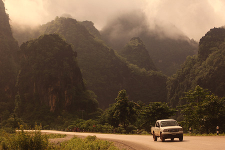 The hilly landscape along the highway 12 between the town and the village of Tha Khaek Mahaxai of May in central Laos on the border with Thailand in Southeast Asiaのeditorial素材