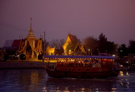A smal Temple and a Evening Tour Boat on the River Chao Phraya in City of Ayutthaya in the north of Bangkok in Thailand, Southeastasia.のeditorial素材