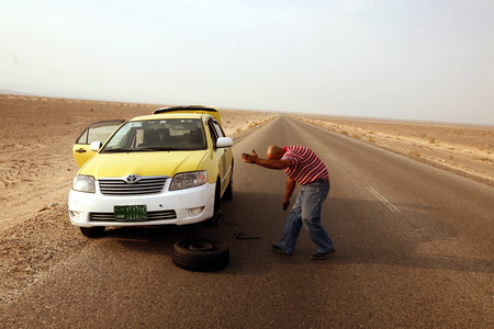 A flat tire on a Taxi on the Desertroad 65 near the Towns Safi and Aqaba in Jordan in the middle east.のeditorial素材