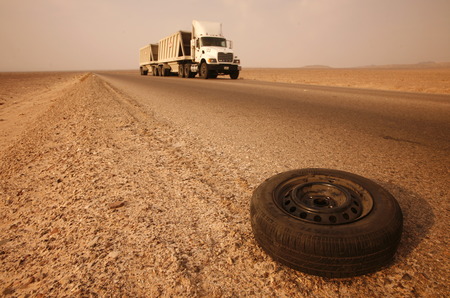 A flat tire on a Taxi on the Desertroad 65 near the Towns Safi and Aqaba in Jordan in the middle east.のeditorial素材