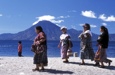People at the coast of Lake Atitlan mit the Volcanos of Toliman and San Pedro in the back at the Town of Panajachel in Guatemala in central America.のeditorial素材