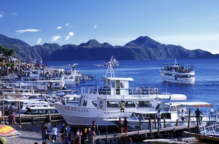 People at the coast of Lake Atitlan mit the Volcanos of Toliman and San Pedro in the back at the Town of Panajachel in Guatemala in central America.のeditorial素材