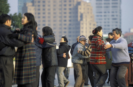 people dancing in the morning on the Bund in front of the skyline of Pudong in the City of Shanghai in China.のeditorial素材