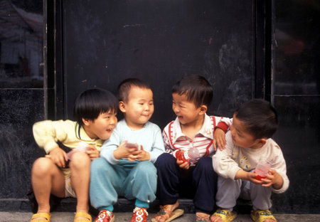 4 childern in a market street in the city of Shenzhen north of Hong Kong in the province of Guangdong in China in east asia.のeditorial素材