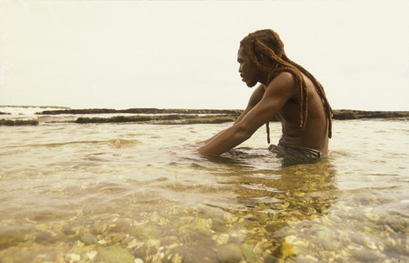 a men on a beach near the city of Santiago de Cuba on Cuba in the caribbean sea.のeditorial素材
