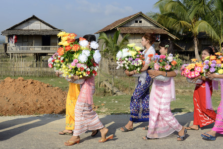 People in traditional dresses at a shinpyu ceremony in a village neat the city of Myeik in the south in Myanmar in Southeastasia.のeditorial素材