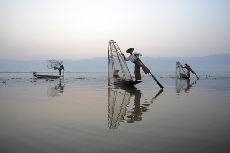 Fishermen at sunrise in the Landscape on the Inle Lake in the Shan State in the east of Myanmar in Southeastasia.のeditorial素材