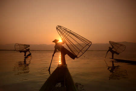 Fishermen at sunrise in the Landscape on the Inle Lake in the Shan State in the east of Myanmar in Southeastasia.のeditorial素材
