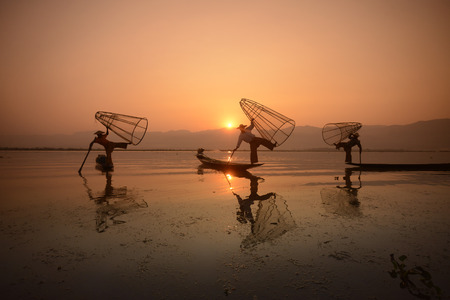 Fishermen at sunrise in the Landscape on the Inle Lake in the Shan State in the east of Myanmar in Southeastasia.のeditorial素材