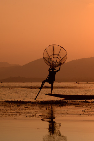 Fishermen at sunset in the Landscape on the Inle Lake in the Shan State in the east of Myanmar in Southeastasia.のeditorial素材