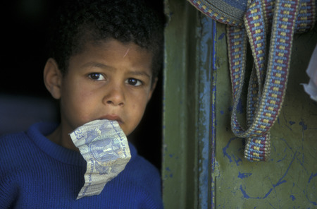 a boy with money in the town and Oasis of Farafra in the lybian or western desert of Egypt in north africaのeditorial素材