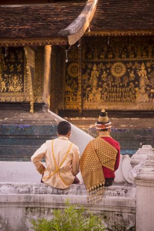 a traditional dresst couple at the wat xieng thong in the town of Luang Prabang in the north of Laos in Southeastasia.のeditorial素材