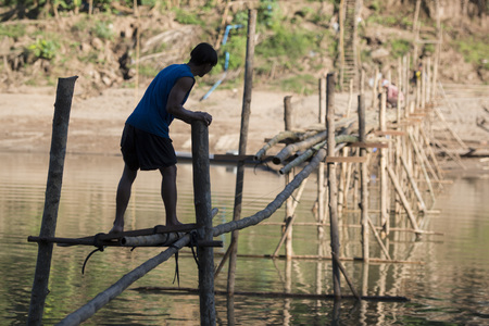 the construction of the Bamboo Bridge over the Nam Khan river in the town of Luang Prabang in the north of Laos in Southeastasia.のeditorial素材