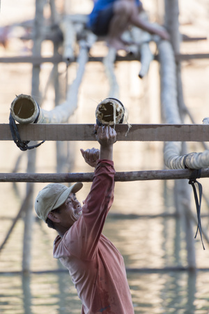 the construction of the Bamboo Bridge over the Nam Khan river in the town of Luang Prabang in the north of Laos in Southeastasia.のeditorial素材