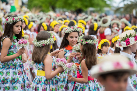 children dressed in colorful clothes at the Festa da Flor or Spring Flower Festival in the city of...