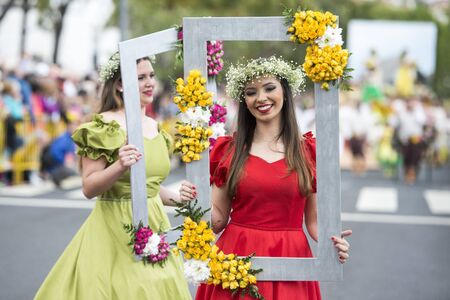 women dressed in colorful clothes at the Festa da Flor or Spring Flower Festival in the city of Funchal on the Island of Madeira in the Atlantic Ocean of Portugal.  Madeira, Funchal, April, 2018のeditorial素材