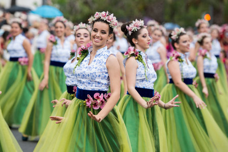 women dressed in colorful clothes at the Festa da Flor or Spring Flower Festival in the city of...