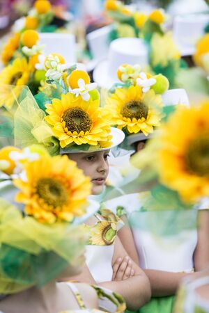 children dressed in colorful clothes at the Festa da Flor or Spring Flower Festival in the city of Funchal on the Island of Madeira in the Atlantic Ocean of Portugal.  Madeira, Funchal, April, 2018のeditorial素材