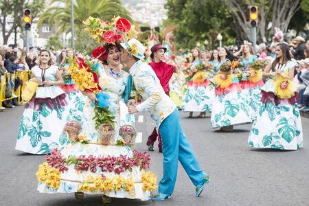 people dressed in colorful clothes at the Festa da Flor or Spring Flower Festival in the city of Funchal on the Island of Madeira in the Atlantic Ocean of Portugal.  Madeira, Funchal, April, 2018のeditorial素材