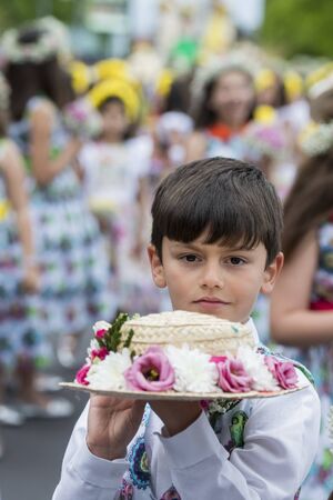 boy dressed in colorful clothes at the Festa da Flor or Spring Flower Festival in the city of Funchal on the Island of Madeira in the Atlantic Ocean of Portugal.  Madeira, Funchal, April, 2018のeditorial素材