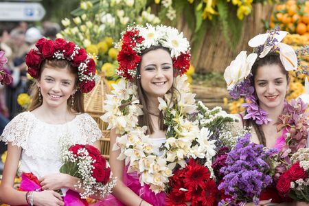 women dressed in colorful clothes at the Festa da Flor or Spring Flower Festival in the city of Funchal on the Island of Madeira in the Atlantic Ocean of Portugal.  Madeira, Funchal, April, 2018のeditorial素材