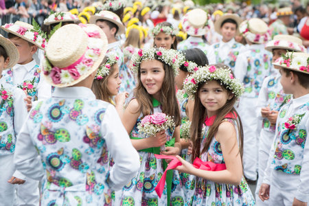 children dressed in colorful clothes at the Festa da Flor or Spring Flower Festival in the city of...
