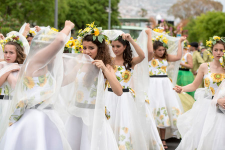women cover their makeup by short rainshower with dressed in colorful clothes at the Festa da Flor...