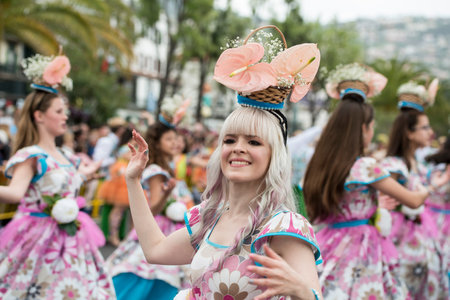 women dressed in colorful clothes at the Festa da Flor or Spring Flower Festival in the city of...