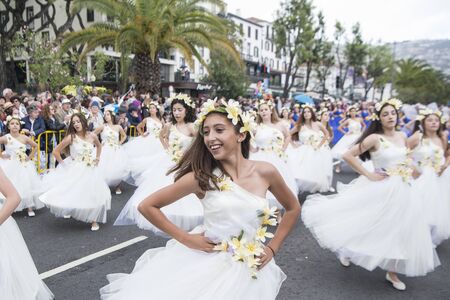 women dressed in colorful clothes at the Festa da Flor or Spring Flower Festival in the city of Funchal on the Island of Madeira in the Atlantic Ocean of Portugal.  Madeira, Funchal, April, 2018のeditorial素材