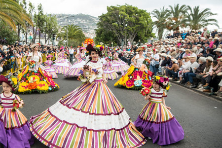 women dressed in colorful clothes at the Festa da Flor or Spring Flower Festival in the city of...